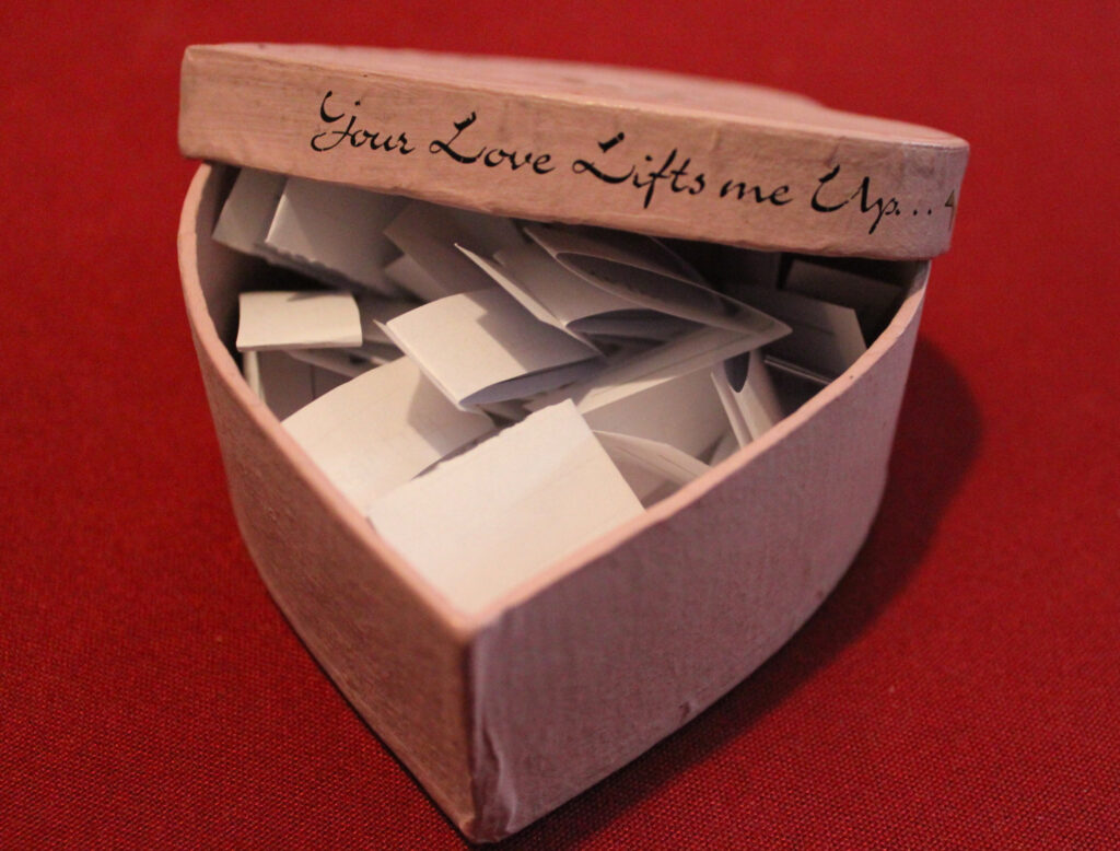 The Heart-Shaped Box filled with strips of folded paper